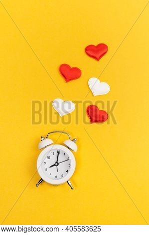 Alarm Clock And Hearts On Color Yellow Background. Place For Text. Vertical Photo