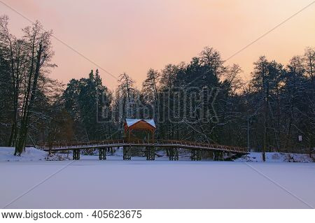 Scenic Winter Sunset Landscape View Of Old Wooden Bridge Over The Frozen Lake In The Village Of Push