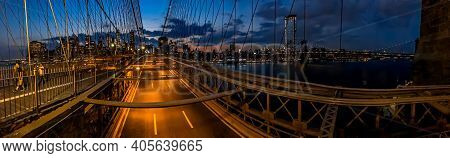 Tourist Enjoying The Twilight Skyline Over New York City From The Brooklyn Bridge As Traffic Flows F