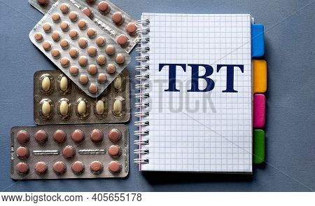 Tbt - Word In A Notebook. Nearby Are Pills On A Gray Background. Medical Concept