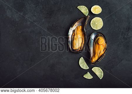 Large Mussels With Lemon On A Black Background. Top View With Space For Text. Two.