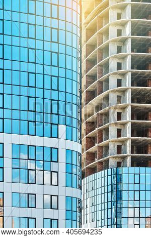 Skyscrapers With Blue Glass And Carcass At Construction Site