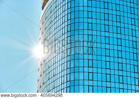 Stylish Skyscraper With Glass Facade Against Clear Blue Sky