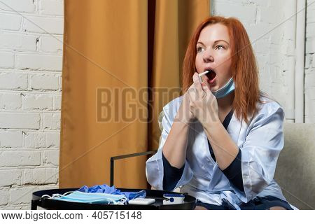 Young Red-haired Woman Treats Throat Spray. Concept: Treatment Of First Signs Of Cold, Seasonal Vira