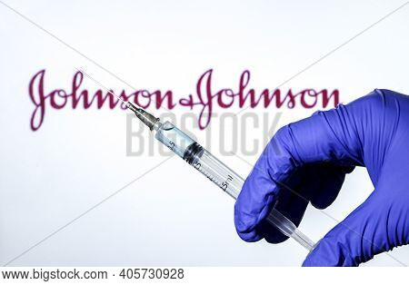 Madrid, Spain- January 7, 2020: Hand On Blue Surgery Glove Holding Syringe With Covid Vaccine. In Th