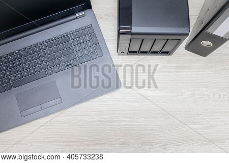 View From Above For Office Workplace With Notebook And Nas Backup Server On A Wooden Background. Bac