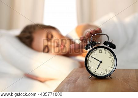 Sleepy Young Woman Stretching Hand To Ringing Alarm Willing Turn It Off. Early Wake Up, Not Getting 