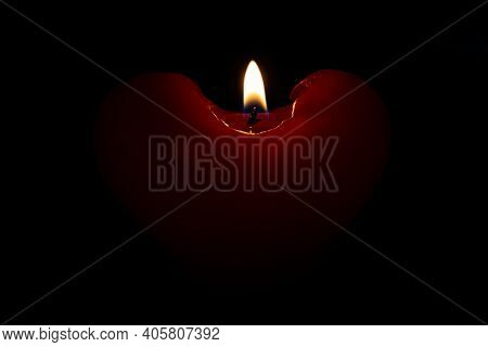 Red Heart Candle Flame Against Dark Background