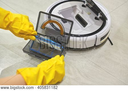Dust Storage Box Case Of Robotic Vacuum Cleaner In Gloved Female Hands. Woman In Protective Gloves T