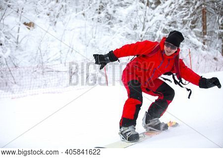 Snowboard Rider Riding Snowboard Fast Down Steep Snowy Mountain Slope, White Snow On Clowdy Winter D
