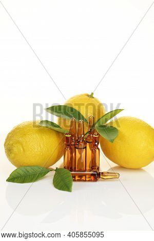 Vitamin C Injection.a Solution Of Vitamin C In Brown Glass Ampoules Set, Lemons On A White Backgroun