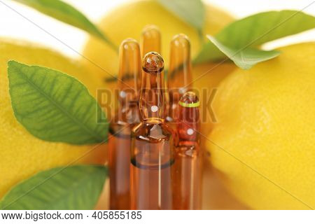 Vitamin C Injection.a Solution Of Vitamin C In Brown Glass Ampoules Set, Lemons On A White Backgroun