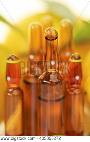Vitamin C Injection.a Solution Of Vitamin C In Brown Glass Ampoules Set, Lemons On A White Backgroun