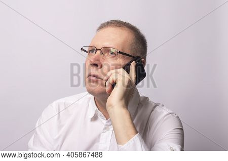 Serious Man Talking On Mobile Phone In White Shirt