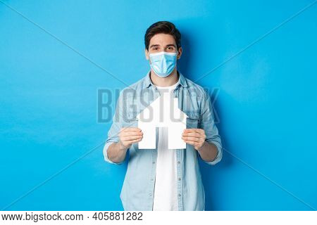 Concept Of Coronavirus, Quarantine And Social Distancing. Young Man Searching Apartment, Showing Hou