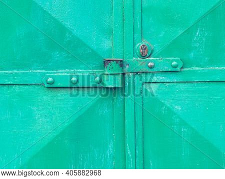 Obsolete Green Door With Locking Latch And Locking Security Insert. Cracked Painted Surface With Rus