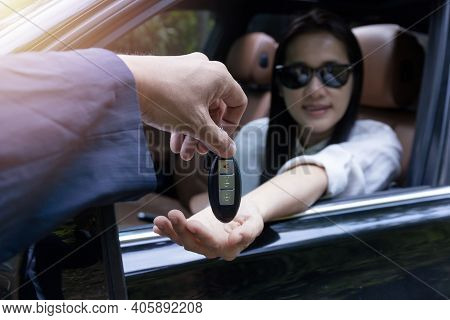 Close Up Of Dealer Giving Key To New Owner Car. New Car. Auto Dealer Giving Woman Automobile Key For