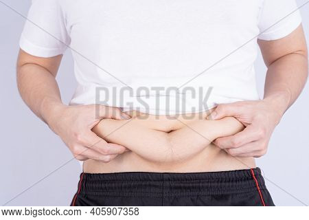 Fat Man Holding Excessive Fat Belly, Overweight Fatty Belly Isolated Grey Background. Diet Lifestyle