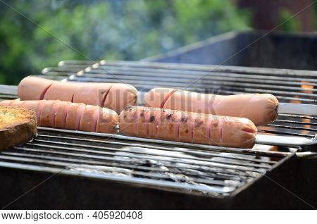 Sausages Are Cooked On A Grill On Coals . Bbq, Outdoor Barbecue .