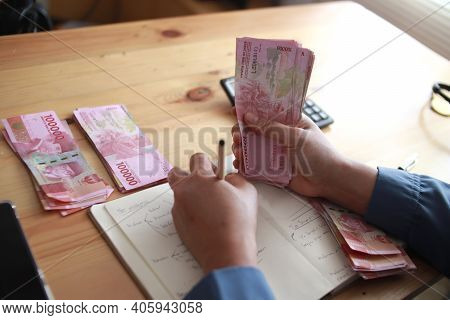 Close Up Of Woman Hand Counting Money Uang Indonesian Rupiah And Making Notes, Money Financial Manag