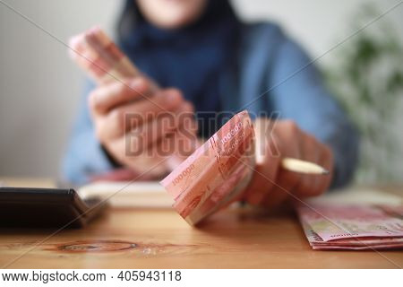 Close Up Of Woman Hand Counting Money Uang Indonesian Rupiah And Making Notes, Money Financial Manag