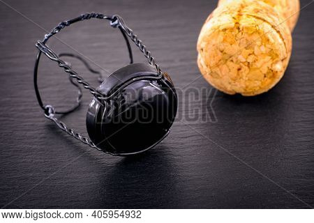 Champagne Muselet With Black Cap And Cork On Black Stone Background. Close-up