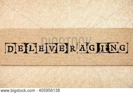 Cardboard With Word Deleveraging Made By Black Alphabet Stamps.