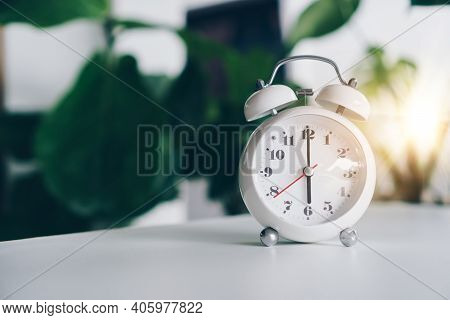 Selective Focus Of Alarm Clock Show 6 O'clock Or 6 A.m. On Table With Nature Bokeh Background. Time 