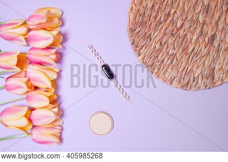 Bouquet Of Tulips , Rottan Circle And Fitness Tracker On Purple Colored Paper Background.