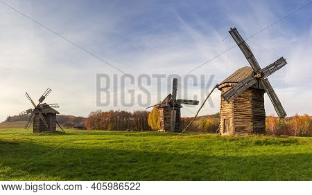 Old Wooden Windmills Standing On The Lawn Against The Evening Sky With Blurred Clouds In Autumn. Pyr