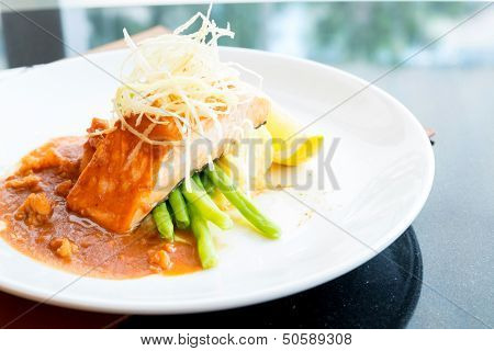 gourmet Grilled Salmon Steak with baked potato and lemon meal