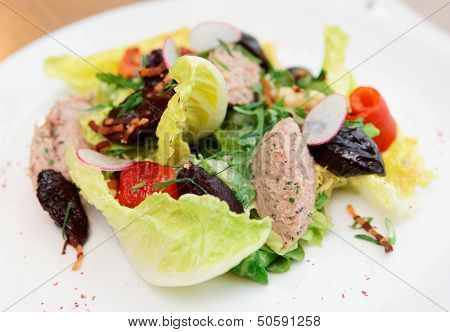 Creative salad with prunes and fish paste on plate, close-up