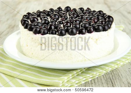 Cheesecake with fresh berries on white plate on wooden table closeup