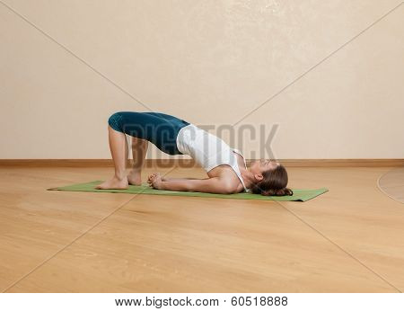 Caucasian Woman Is Practicing Yoga At Studio (setu Bandkha Sarvangasana)
