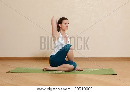Caucasian Woman Is Practicing Yoga At Studio (gomukhasana)