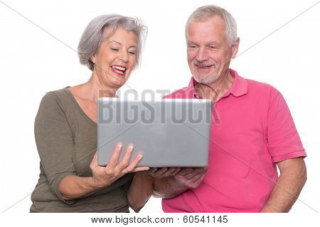 Senior couple with computer in front of white background