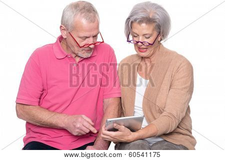 Senior couple with tablet computer in front of white background