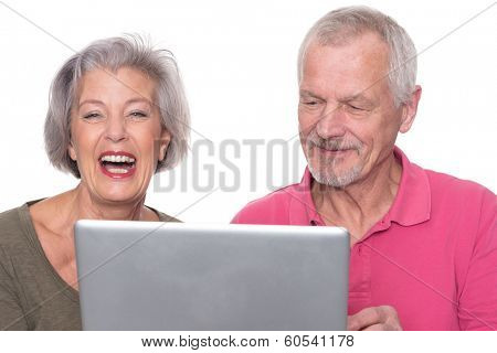 Senior couple with computer in front of white background
