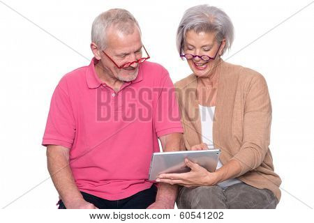 Senior couple with tablet computer in front of white background