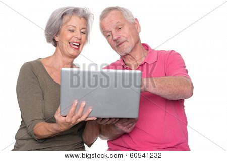 Senior couple with computer in front of white background