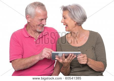 Senior couple with tablet computer in front of white background