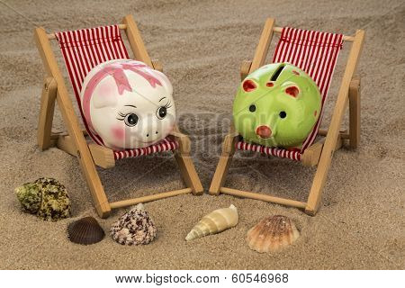 deck chair with piggy bank on the sandy beach. symbolic photo for travel costs, holidays, vacations. save on holiday