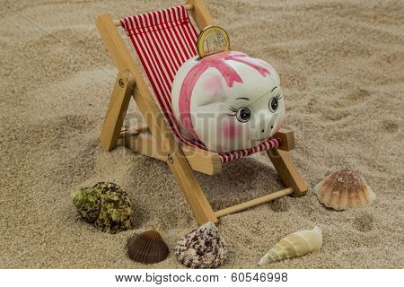 beach chair with euro currency on the sandy beach. symbolic photo for travel costs, holidays, vacations. save on holiday