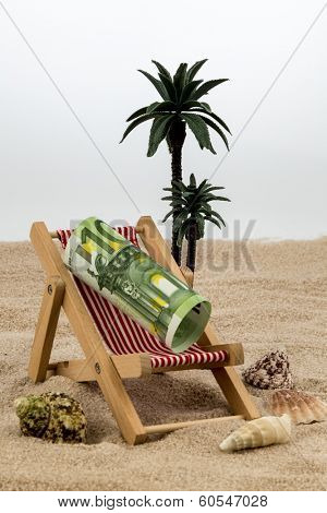 a deck chair with a euro banknote. symbolic photo for saving on holiday and when traveling