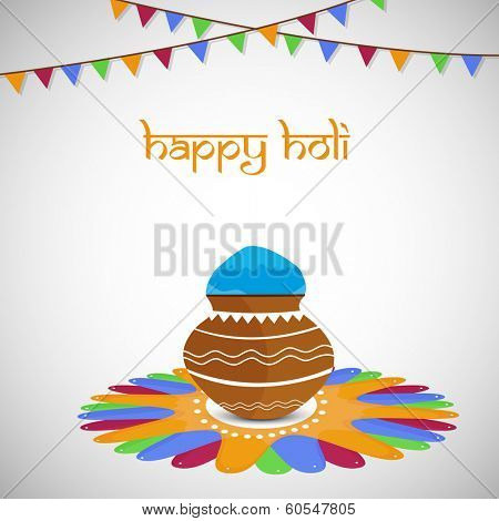 Indian colour festival Happy Holi celebrations with beautiful mud pot with full of colour on grey background.