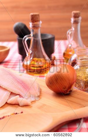 Raw fish tilapia on cutting board and spices