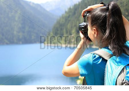 woman tourist/photographe r taking photo with digital camera in jiuzhaigou national park,china