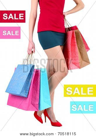 Concept of discount. Female in red shoes holding shopping bags isolated on white