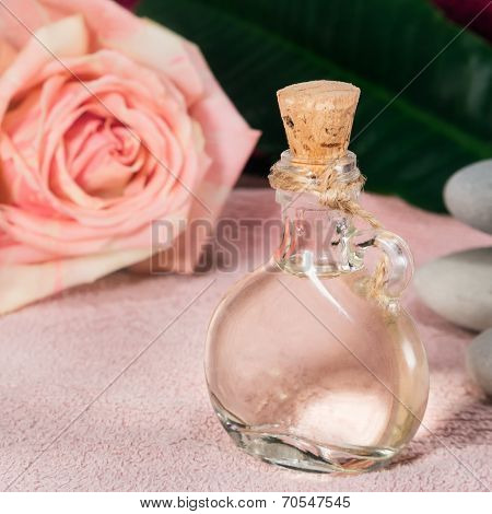Bottle with attar against rose and stones spa