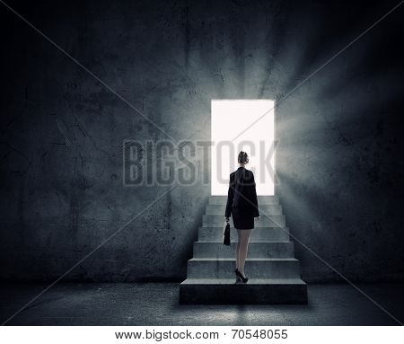 Silhouette of businesswoman with briefcase standing in doorway